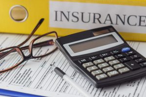 Clean insurance form, folders, pen, glasses and calculator