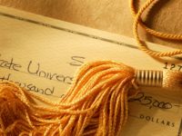 Gold tassel on a check written for college tuition